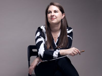 Karen Ni Bhroin conductor, sat in chair holding baton